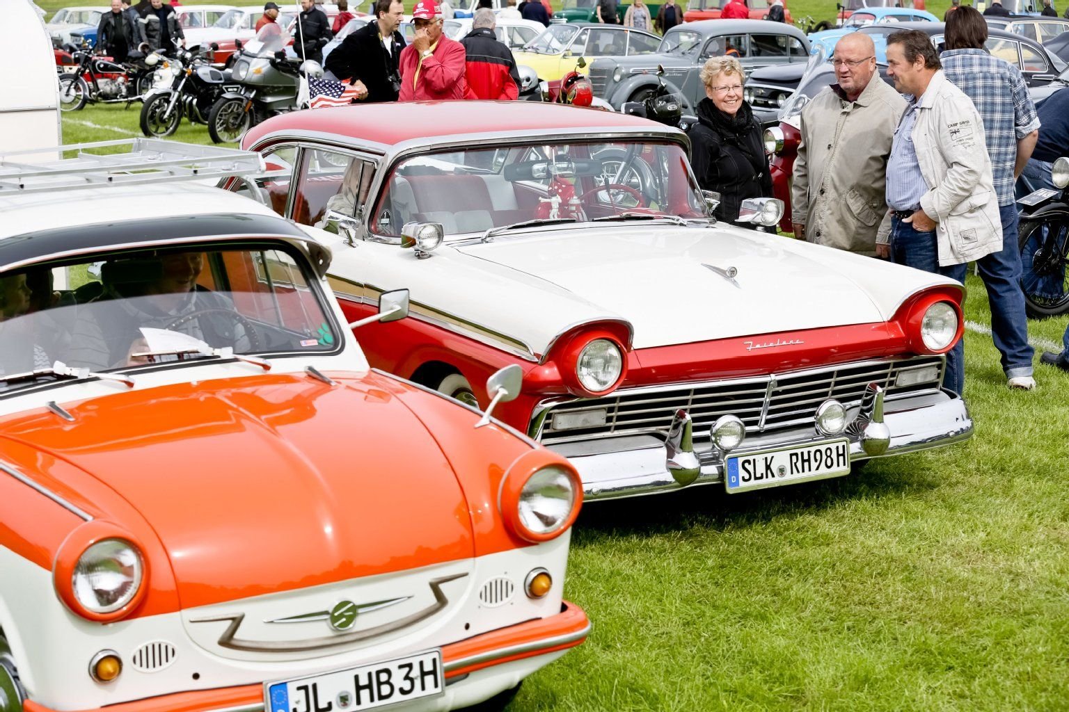 Besucher des 3. Magdeburger Oldtimertreffens schauen sich im Elbauenpark Magdeburg (Sachsen-Anhalt) historische Fahrzeuge unterschiedlicher Bauart und Marke an.