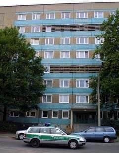Ein Streifenwagen der Polizei passiert ein Wohnhaus in Cottbus, in dem in einer Tiefkühltruhe ein totes Kind aufgefunden wurde. Die Leiche eines kleinen Jungen hat möglicherweise eineinhalb Jahre lang in der Tiefkühltruhe der elterlichen Wohnung gelegen. (Foto: dpa)