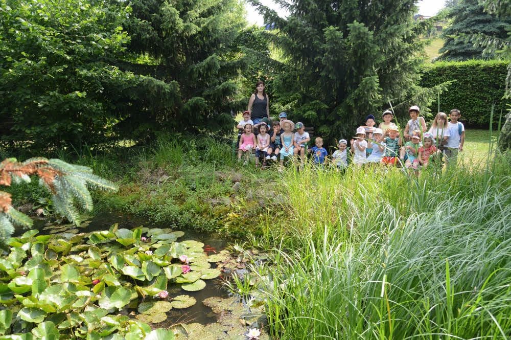 Mädchen und Jungen des Montessori-Kinderhauses besuchen den Goldfischteich der Gartenanlage Am Fockendorfer Grund.
