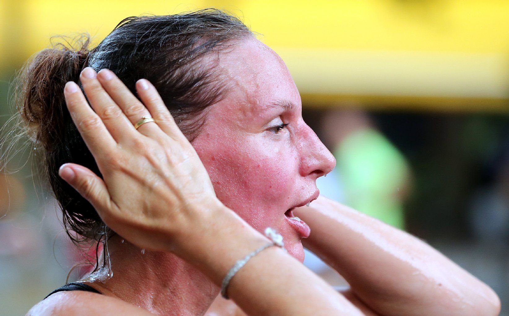 Eine Teilnehmerin des 22. Vattenfall City-Nacht wischt sich bei Temperaturen um 30 Grad Celsius am 27.07.2013 während des 5 km-Laufs auf dem Kurfürstendamm in Berlin den Schweiß aus dem Gesicht.