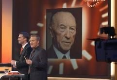 Die Moderatoren Steffen Seibert (l) und Johannes B. Kerner stehen am Freitagabend (28.11.2003) in Berlin in der ZDF-Sendung "Unsere Besten - Wer ist der größte Deutsche?" vor einem Porträt des Siegers Konrad Adenauer. (Foto: dpa)