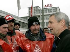 Göttlicher Beistand: Am Donnerstag (23. Februar) besuchte der Bamberger Erzbischof Ludwig Schick (r.) die streikenden Beschäftigten des Nürnberger AEG-Hausgerätewerkes. (Foto: dpa)