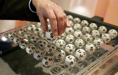 Ein Mitarbeiter von Lotto bestückt in einem Fernsehstudio die Lottomaschine mit den Kugeln. (Foto: dpa)