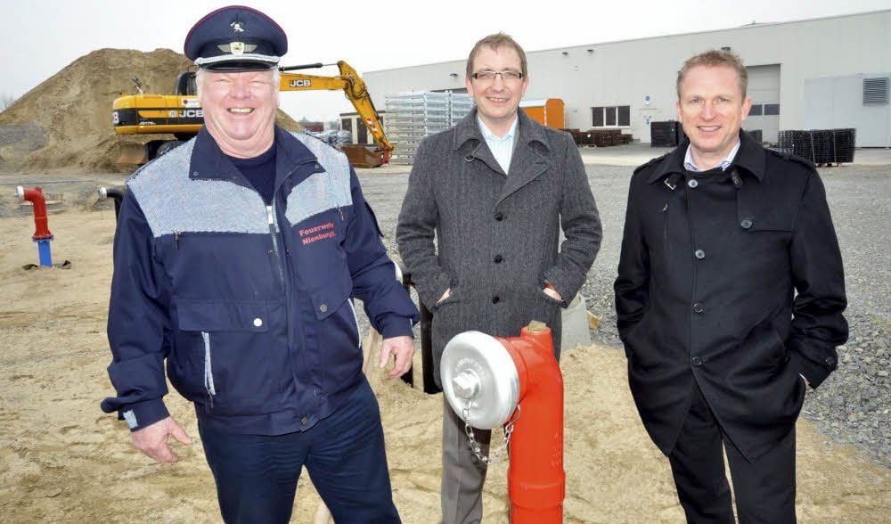 Der Stadtwehrleiter Rudi Waldeck (l.), Bürgermeister Markus Bauer (M.) und der Geschäftsführende Gesellschafter von Exte, Arn Friedl, vor dem Wasserspeicher für das Löschwasser.