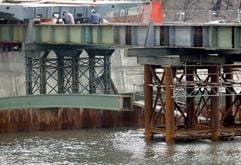 Monteure befestigen am Mittwoch (03.03.2004) im ostsächsischen Görlitz über der Neiße das erste Stahlbauteil der neuen deutsch-polnischen Altstadtbrücke. Schon im Herbst sollen hier die ersten Fußgänger über die 82 Meter lange Brücke laufen. Der Bau über den Grenzfluss kostet 1,6 Millionen Euro. (Foto: ddp)
