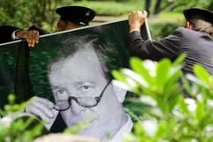 Mitarbeiter eines Bestattungsunternehmen stellen am Sonntag (29.08.2004) auf dem Friedhof in der Heerstraße in Berlin ein Porträtfoto von Günter Rexrodt an dessen Grab auf. Der FDP-Politiker, ehemalige Bundeswirtschaftsminister und frühere Berliner Finanzsenator war am 19.08.2004 im Alter von 62 Jahren nach längerer Krankheit an einem plötzlichen Herztod gestorben. (Foto: dpa)