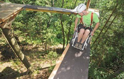 Der Erlebnispädagoge Thomas Denk fährt in Schönberg (Niederbayern) mit einem Rollstuhl im Hochseilpark. (FOTO: DPA)