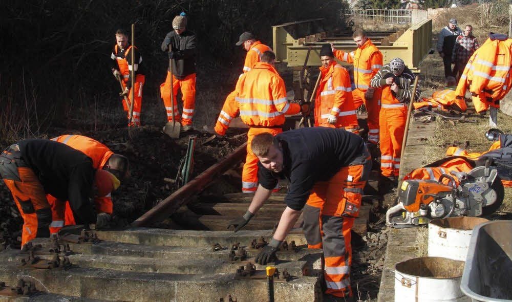 Gleisbau-Azubis wechseln rissige Betonschwellen aus.