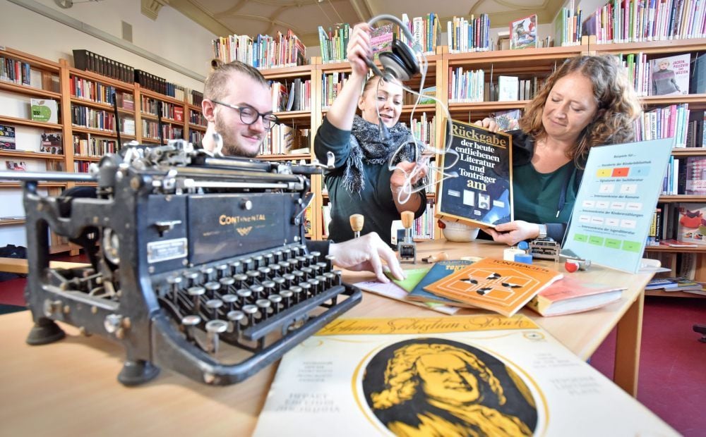 Susanne Ackermann, Emöke Dippold und Moritz Schinke bereiten die Aktionen zum Bibliotheksjubiläum vor, die am Mittwoch stattfinden.