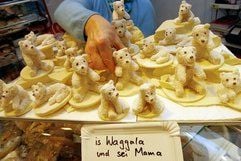 Konditorin Ingrid Neef präsentiert in ihrem Geschäft in Nürnberg Eisbären aus Marzipan. Anlässlich der Geburt eines Eisbären im Nürnberger Tiergarten stellte die Konditorei die Marzipan-Eisbären mit einem «Fell» aus Kokosflocken her. Auf dem Schild steht übersetzt: «Das Kleine und seine Mutter». (Foto: dpa)