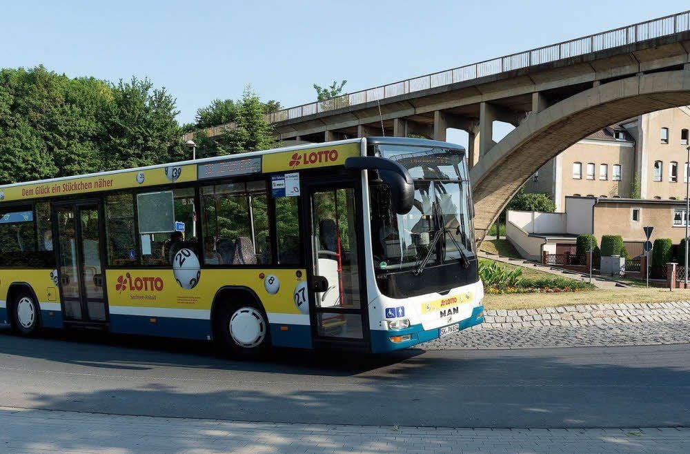 Ein Bus der PNVG fährt am Kreisel in Mücheln, im Hintergrund das Viadukt.