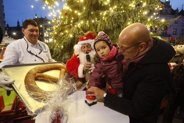 OB Bernd Wiegand (rechts) macht mit der kleinen Lotta (4) den Weihnachtsbaum in Halle an.