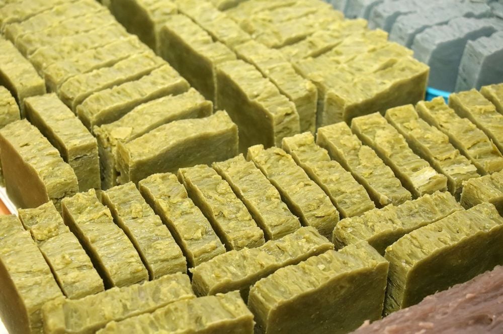 Der fest gewordene Seifenblock wird in Stücke geschnitten.