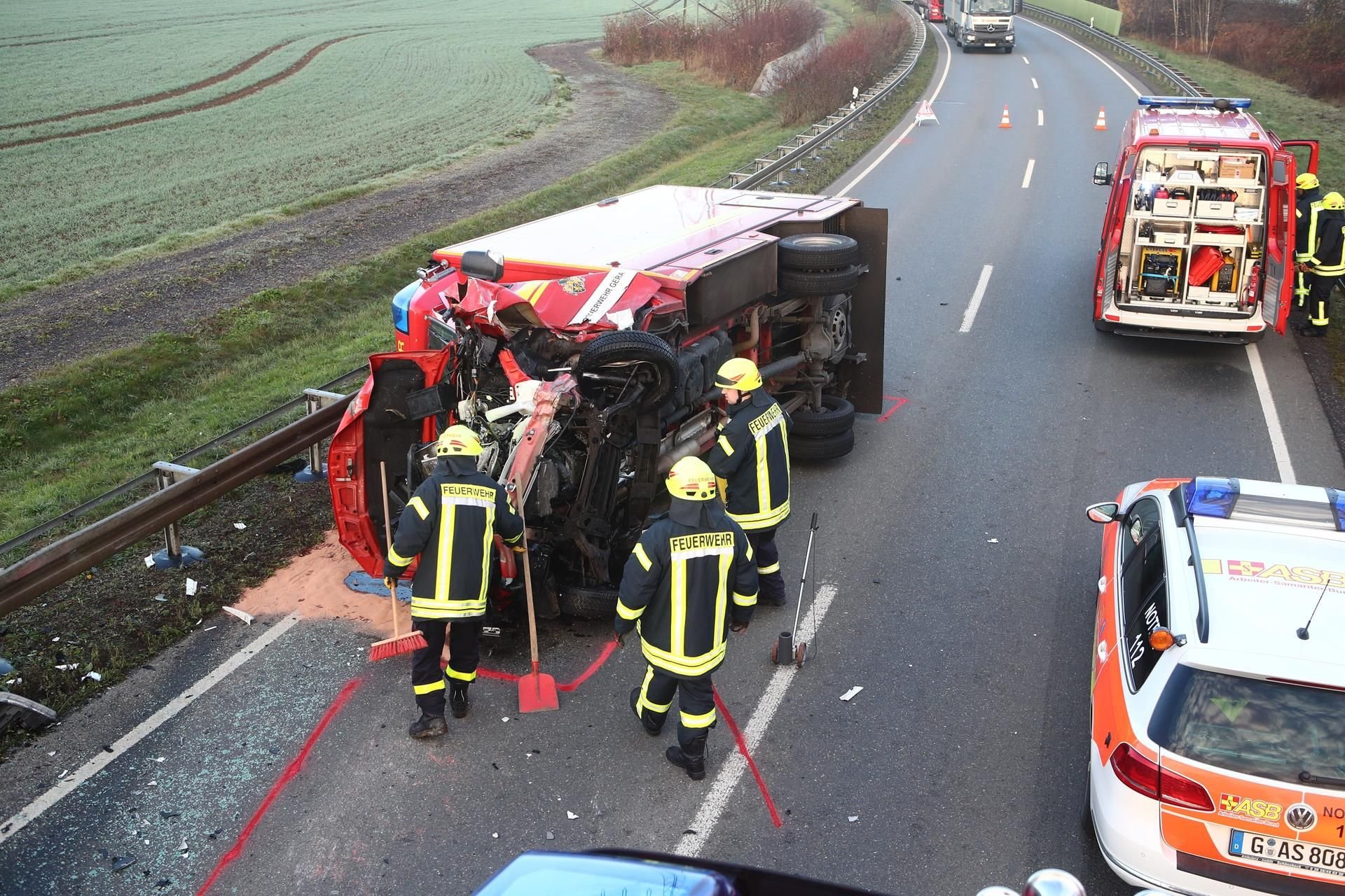 Rettungskräfte stehen vor einem Rettungswagen der Feuerwehr auf der Bundesstraße 7 zwischen Bad Köstritz und Caaschwitz.