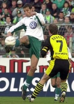 Der Dortmunder Stefan Reuter (r) setzt seine Karriere beim BVB fort. Hier in einem Kampf mit dem Wolfsburger Diego Klimowicz (l), der sich in dieser Szene gegen ihn durchsetzt (Foto: dpa).