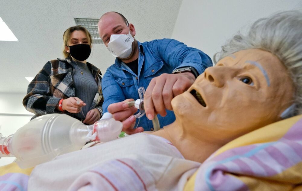 Ausbilder Constantin Reinhold (rechts) erklärt der Auszubildenden Michelle Aust an einem Dummy die Vorgehensweise beim Intubieren.