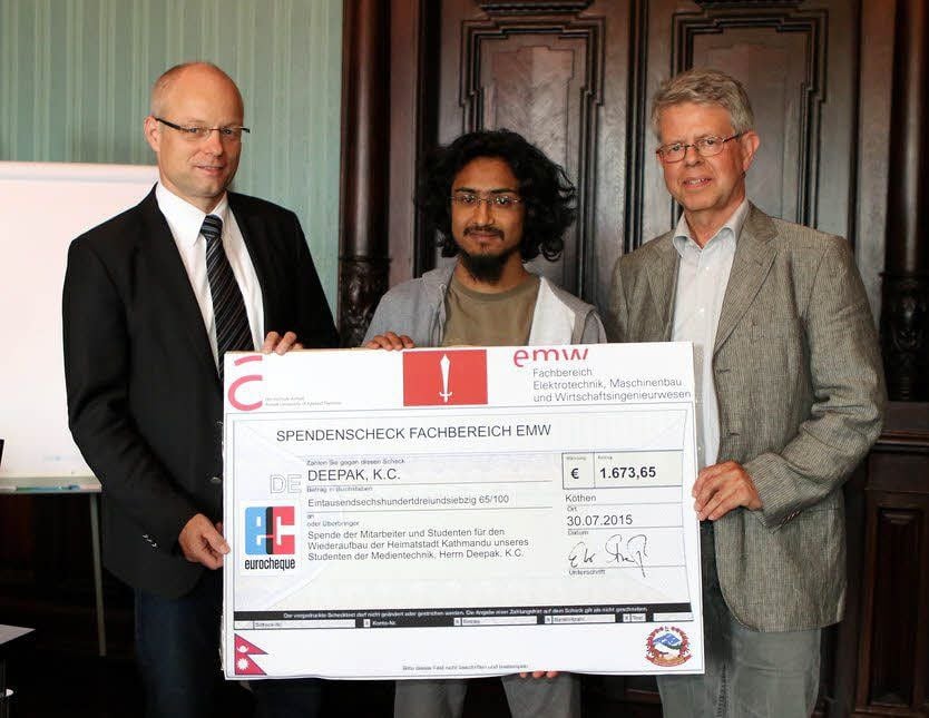 Der Professor für Medientechnik Steffen Strauß (l.) und Dekan Ulrich-Michael Eisentraut (r.) überreichen die Spende an Student Deepak K.C.