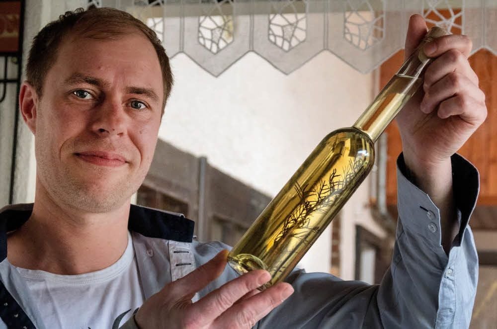 Christian Hodel mit einer Flasche seines Lakritztagetes-Likörs. Den hat er jetzt zum Wettbewerb eingereicht.