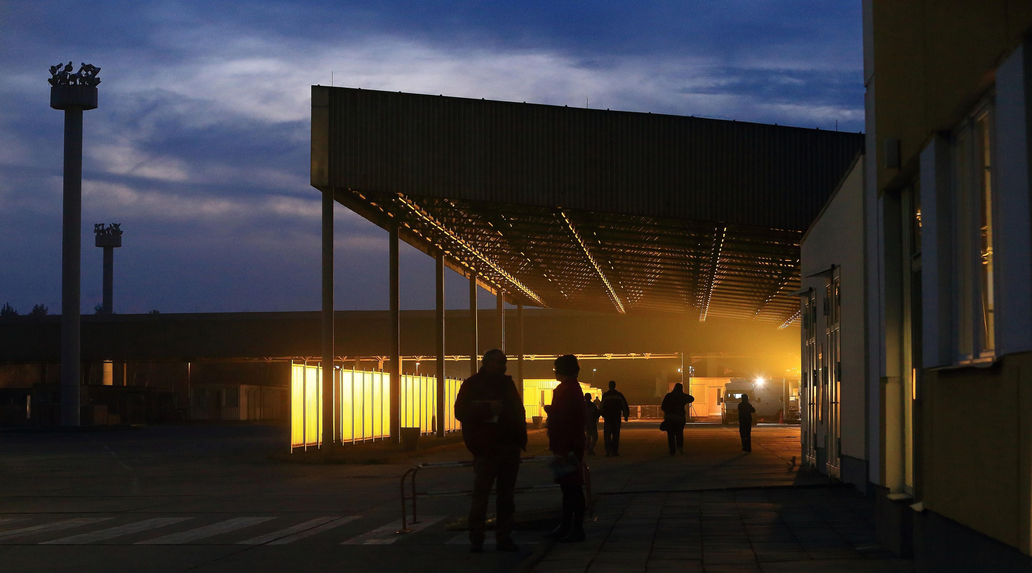 Besucher gehen in der Abenddämmerung über das Gelände der Gedenkstätte „Deutsche Teilung“ in Marienborn.