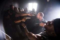 Chev Chelios (Jason Statham, 2.v.r.) steht im neuen Kinofilm «Crank» inmitten einer Gang, die ihn mit Waffen bedroht (undatiertes Szenenfoto). (Foto: dpa)