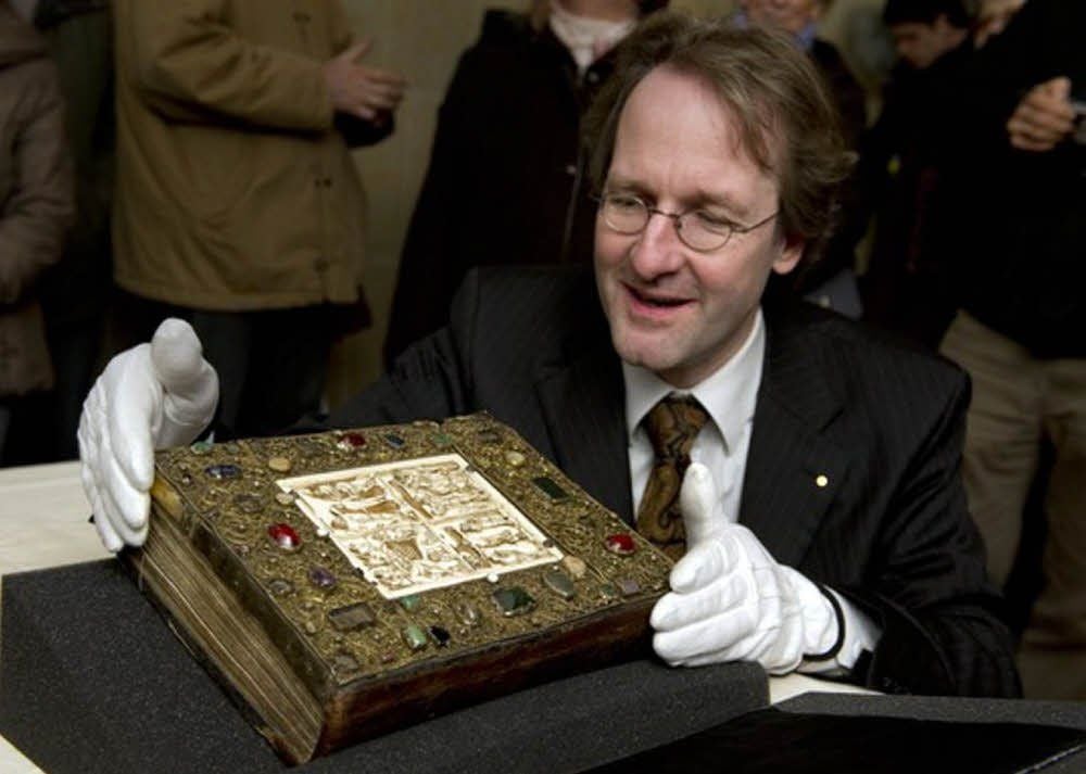 Kustos Thomas Labusiak mit dem Otto-Adelheid-Evangeliar, als es vor wenigen Jahren für eine Ausstellung aufgeklappt wurde.