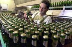 Ein Mitarbeiter des Getränkekonzerns Brau und Brunnen prüft an einer Abfüllanlage in Dortmund eine Flasche «Jever». (Foto: dpa)