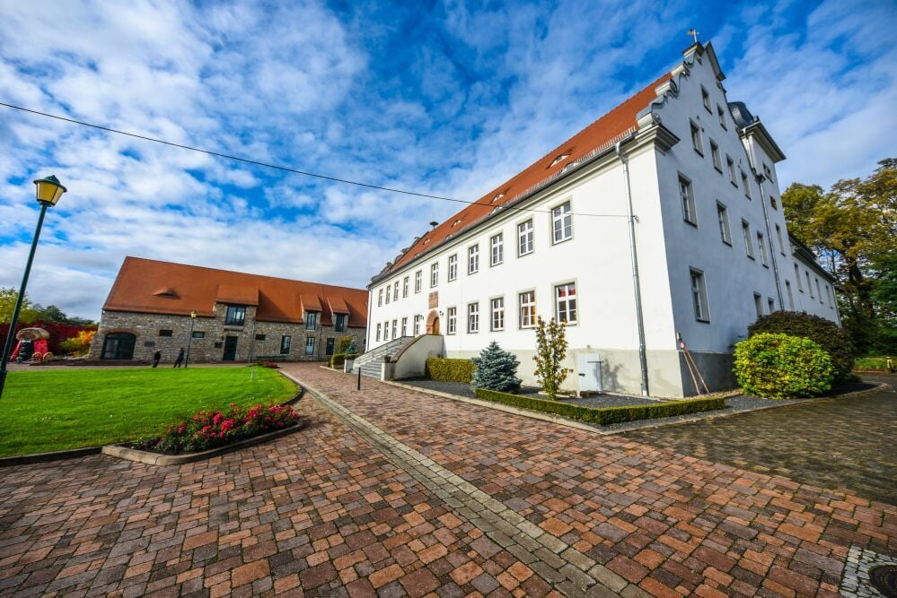 Der alte Gutshof gehört heute fast komplett der Gemeinde. Im Schloss befindet sich die Kita, der alte Pferdestall (l.) ist soziokulturelles Zentrum.