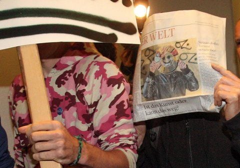 Begleitet von Sympathisanten und verdeckt mit einem Zeitungsartikel über seine Person kommt in Hamburg der Graffiti-Sprayer Walter F. (re.), alias «OZ», in das Amtsgericht Barmbek. (FOTO: DPA)