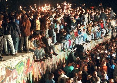 Jubelnde Menschen sitzen mit Wunderkerzen auf der Berliner Mauer am 11.11.1989. Nach der Öffnung eines Teils der deutsch-deutschen Grenzübergänge in der Nacht vom 9. auf den 10. November 1989 reisten Millionen DDR-Bürger für einen kurzen Besuch in den Westen. (FOTO: DPA)