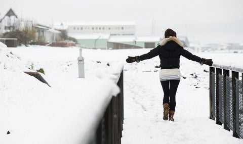 Eine Frau steht im Zentrum von Reykjavik im Schnee. (FOTO: DPA)