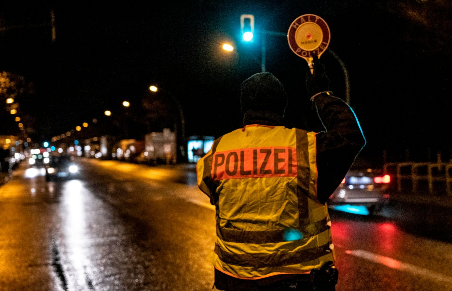 Ein Polizist winkt im Stadtteil Neukölln ein Fahrzeug aus dem Verkehr.