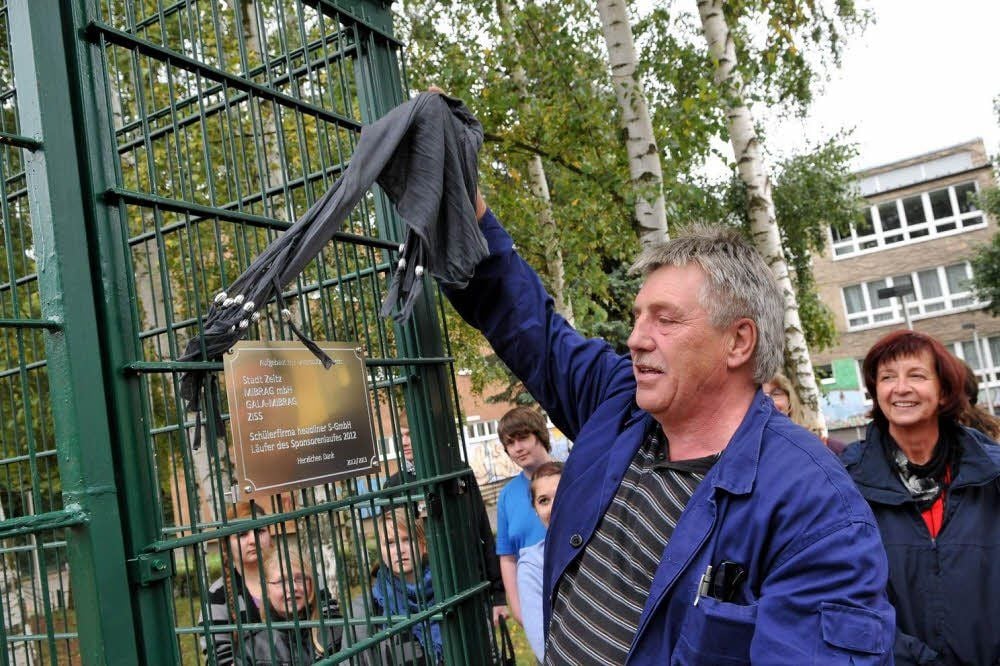 Hausmeister Roland Kahn enthüllt die Erinnerungstafel an der neuen Anlage.