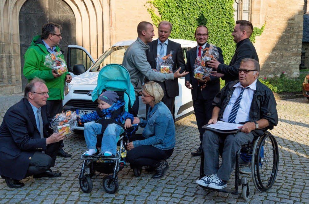 Ministerpräsident Reiner Haseloff (CDU, l.) übergibt ein Fahrzeug an Jan und Susann Wünsch damit diese ihren behinderten Sohn Noah besser betreuen können.
