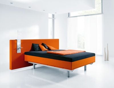 Das Doppelbett in leuchtendem Orange wird am besten mit dezenten Farben kombiniert. (FOTO: DPA)