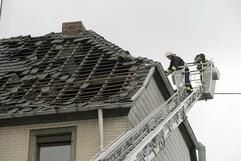 Feuerwehrleute sichern am Dienstag (22.08.2006) im Ortskern von Brohl ein Dach, das in der Nacht von einem Tornado beschädigt wurde. (Foto: dpa)