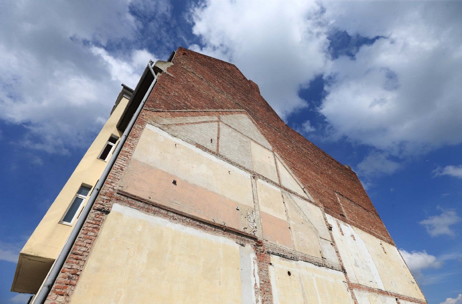 Die Giebelwand eines Wohnhauses mit Spuren eines abgerissenen Gebäudes in Schönebeck. Zahlreiche Bauprojekte verzögern sich weiter.