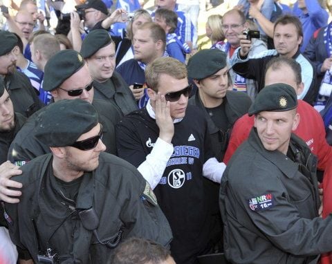 Schalkes Torwart Manuel Neuer wird am Sonntag beim Autokorso des FC Schalke 04 von Polizisten durch die Menge begleitet. (FOTO: DAPD)