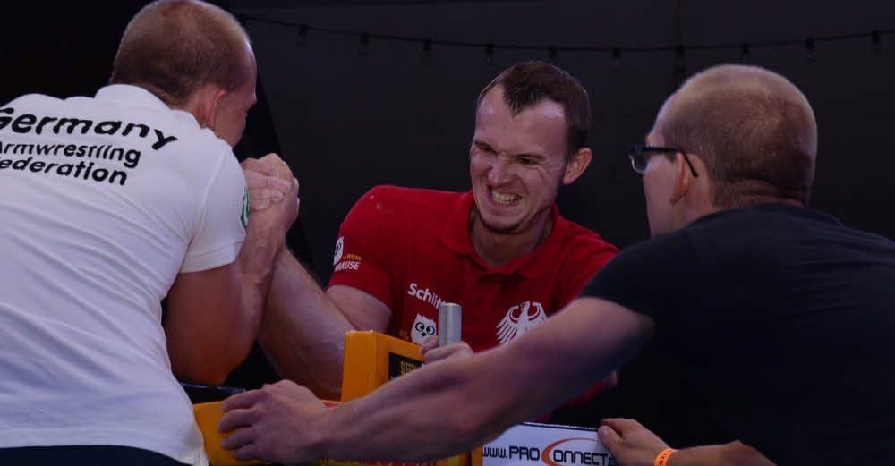 Armwrestler Matthias Schlitte (Mitte) steht die Anspannung ins Gesicht geschrieben.