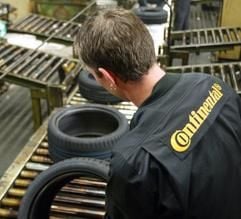 Ein Unternehmensmitarbeiter kontrolliert einen Continental Pkw-Reifen an einem Laufband hinter einer Presse im Continental Werk in Hannover. (Foto: dpa)