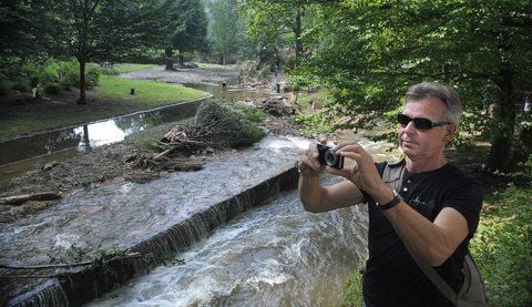 Ein Tourist macht sich im Bad SchandauerStadtpark ein Bild von der Verwüstung, dieder Bergfluss Kirnitzsch angerichtet hat. (FOTO: ANDREAS STEDTLER)