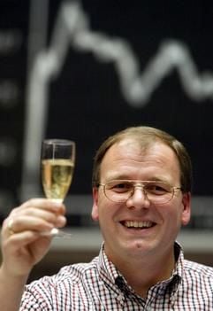Ein Händler prostet am Dienstag (30.12.2003) in der Frankfurter Börse den Fotografen mit Champagner zu. (Foto: dpa)