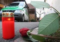 Eine Kerze, eine Rose und ein Polizeifahrzeug stehen am Montag (31.10.2005) vor dem Tatort in Saltendorf (Landkreis Schwandorf). (Foto: dpa)