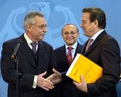 Der Vorsitzende des Sachverständigenrates zur Begutachtung der gesamtwirtschaftlichen Entwicklung (SVR), Wolfgang Wiegard (l), übergibt am Mittwoch (17.11.2004) in Berlin Bundeskanzler Gerhard Schröder (r) das Jahresgutachten der Wirtschaftsweisen für das Jahr 2005. Im Hintergrund steht Wolfgang Franz, Mitglied des Sachverständigenrates. Der Bericht trägt den Titel «Erfolge im Ausland - Herausforderungen im Inland». Die Gutachter erwarten für 2005 ein Wirtschaftswachstum von 1,4 Prozent. (Foto: dpa)