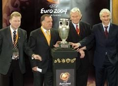 Die Trainer der Gruppe D, Alexander Starkov (Lettland - v.l.), Dick Advocaat (Niederlande), Karel Bruckner (Tschechien) und Rudi Völler (Deutschland) stellen sich am Sonntag (30.11.2003) in Lissabon neben den EM-Pokal. (Foto: dpa)
