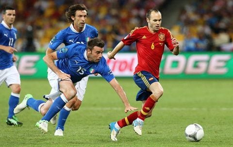 Spaniens Andres Iniesta (r.) läuft im EM-Finale seinen italienischen Verfolgern davon. Iniesta ist zum Spieler des Turniers gekürt worden. (FOTO: DPA)