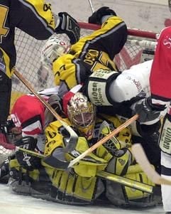 Von Freund und Feind umlagert ist der Keeper der Krefeld Pinguine Robert Müller (M). In der ausverkauften KölnArena kämpfen am Freitag (11.04.2003) im ersten Finalrundenspiel die Kölner Haie gegen die Krefeld Pinguine um den DEL- Meistertitel, der nach drei Siegen bei fünf möglichen Spielen feststeht. Das Spiel endete 2:5. (Foto: dpa)