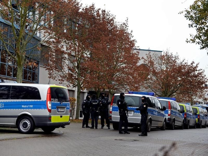 Polizisten stehen vor einem Bürokomplex in Dietzenbach (Hessen). Foto: Susann Prautsch