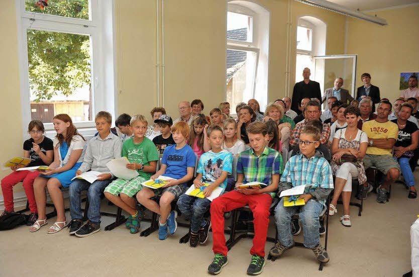 Schüler und Eltern hören aufmerksam zu.