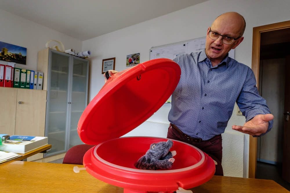 Mathias Kolander demonstriert die schwimmende Falle anhand einer Stoff-Ratte.