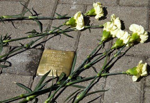 Schüler der Bad Dürrenberger Borlach-Sekundarschule sowie junge Leute aus der Ukraine und aus Russland legten Montag nach der Verlegung des neuen Stolpersteins gelbe Nelken nieder. (FOTO: NADINE STENZEL)